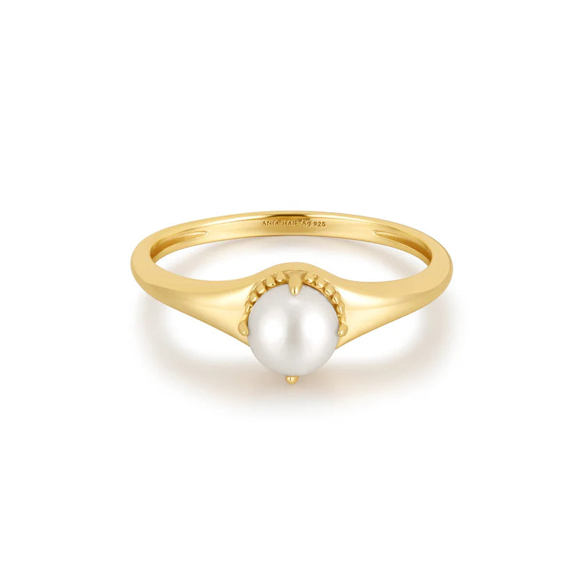 Gold ring with a pearl on a white background